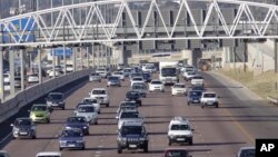 Cars stream underneath a gantry on a road to Pretoria, South Africa, May 4, 2012. 