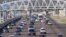 Cars stream underneath a gantry on a road to Pretoria, South Africa, May 4, 2012. 