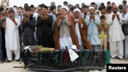 Des Afghans prient lors de funérailles d'une des victimes de l'attentat suicide à Kaboul, Afghanistan, le 24 juillet 2016.