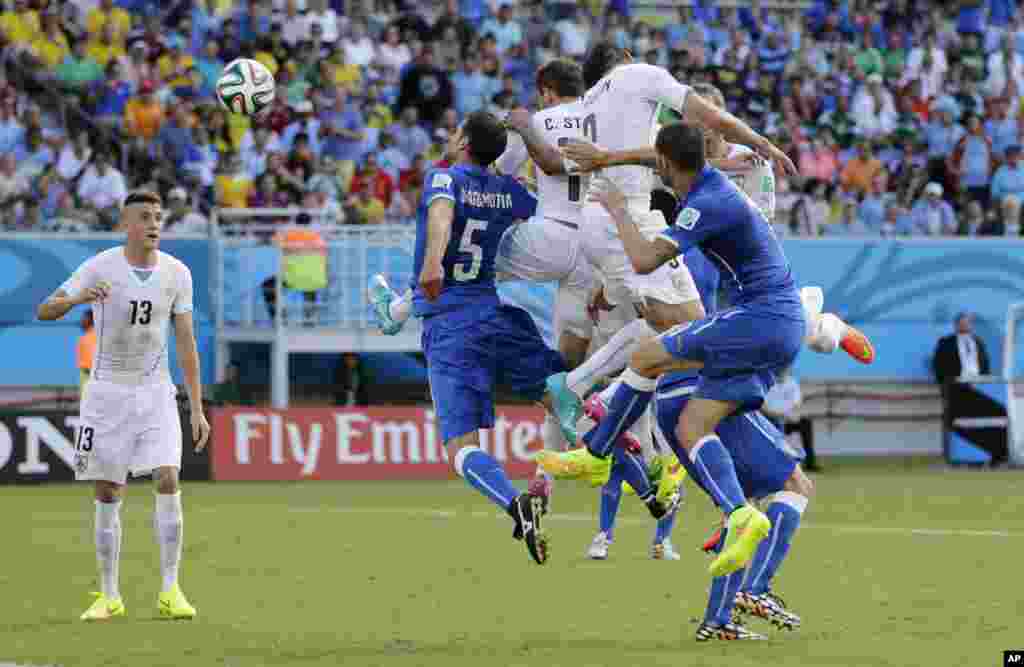 Uruguay&#39;s Diego Godin, second right, heads the ball to score his side&#39;s first goal during the group D World Cup soccer match between Italy and Uruguay at the Arena das Dunas in Natal, Brazil.