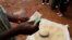 FILE - A trader counts money as he sells maize near the capital Lilongwe, Malawi, Feb. 1, 2016. A report indicates Malawi's foreign exchange reserves in the first quarter of 2022 sharply dropped compared to the fourth quarter of 2021.