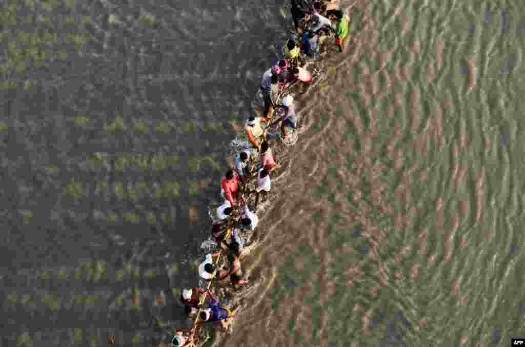 កម្មករ​ទាញ​ខ្សែ​នៅពេល​ដែល​ពួកគេ​កំពុង​សាងសង់​ស្ពាន​បណ្តែត​ទឹក​មួយ​នៅ​ទន្លេ Ganges សម្រាប់​ពិធី​បុណ្យ​ Kumbh Mela ដែល​ជិត​មកដល់​ក្នុង​ទីក្រុង​ Allahabad ប្រទេស​ឥណ្ឌា។