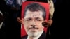 A supporter holds a poster of Egypt's Islamist President Mohammed Morsi with Arabic that reads, "Sisi traitor," during a rally, in Nasser City, Cairo, Egypt, July 4, 2013. 