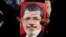 A supporter holds a poster of Egypt's Islamist President Mohammed Morsi with Arabic that reads, "Sisi traitor," during a rally, in Nasser City, Cairo, Egypt, July 4, 2013. 