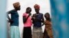 Girls check their ratio cards as they wait to receive food during food distribution in Minkaman, Lakes State, South Sudan, June 26, 2014. 