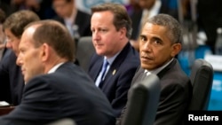 Presiden AS Barack Obama duduk bersama Perdana Menteri Australia (kiri) dan PM Inggris David Cameron dalam sidang paripurna KTT pemimpin G20 di Brisbane November 15, 2014. Western leaders attending a G20 summit bl