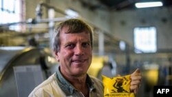 L'ancien président du Commercial Farmers Union (CFU), Deon Theron, tient un paquet de lait aigre (maas) dans son usine de traitement du lait à Beatrice, au Zimbabwe, 27 novembre 2017 .