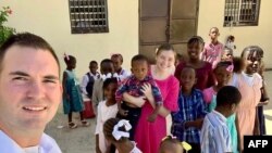 In this undated photo courtesy of Missions in Haiti, U.S. missionaries Davy and Natalie Lloyd pose with Haitian children. Gang members killed the couple in Port-au-Prince on May 23, 2024.