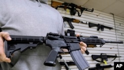 Džon Džekson, vlasnik prodavnice Capitol City Arms Supply pokazuje pušku AR-15 koja se prodaje u njegovoj prodavnici. 