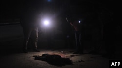 Arhiva - Pripadnici somalijskih snaga bezbednosti gledaju telo osumnjičenog borca Al Šabab u Mogadišu, Somalija, 5. novmbra 2018.