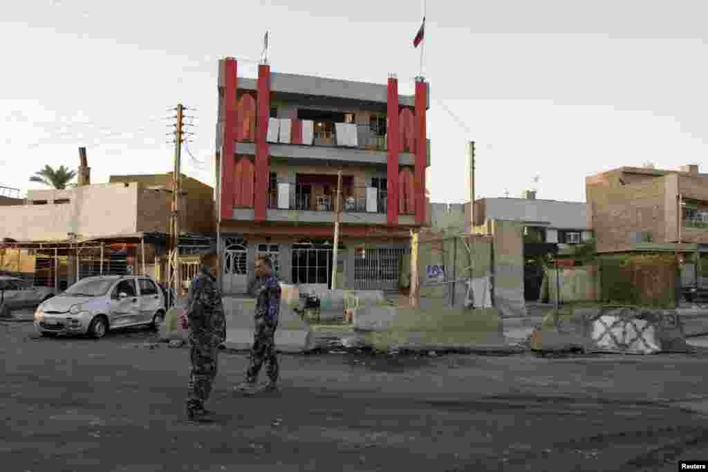 Police inspect the site of an attack that killed at least 18 people and wounded about 50 people when two parked car bombs went off in two mainly Shi&#39;ite districts, in Baghdad&#39;s Al-Amil district, Sept. 2, 2014.