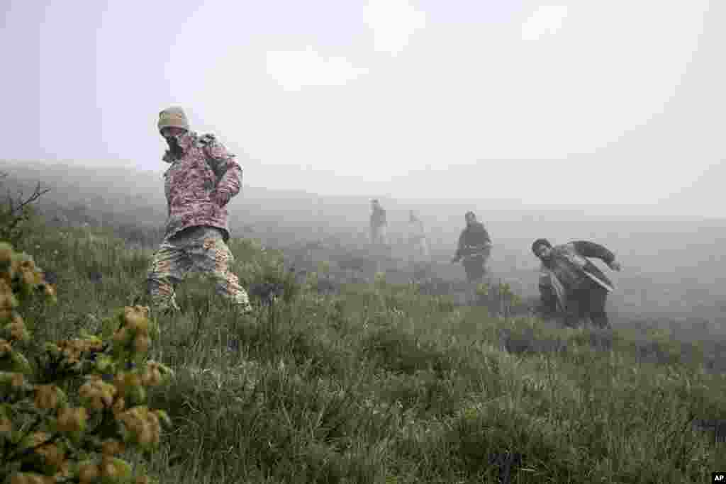 In this photo provided by Moj News Agency, rescue team members search for the wreckage of the helicopter carrying Iranian President Ebrahim Raisi after it crashed in Varzaghan in northwestern Iran, May 20, 2024.