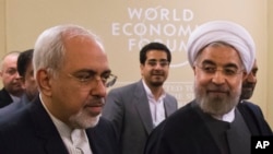Presiden Iran Hassan Rouhani (kanan), dan Menlu Iran Mohammad Javad Zarif, menghadiri Forum Ekonomi Dunia di Davos, Swiss (22/1).