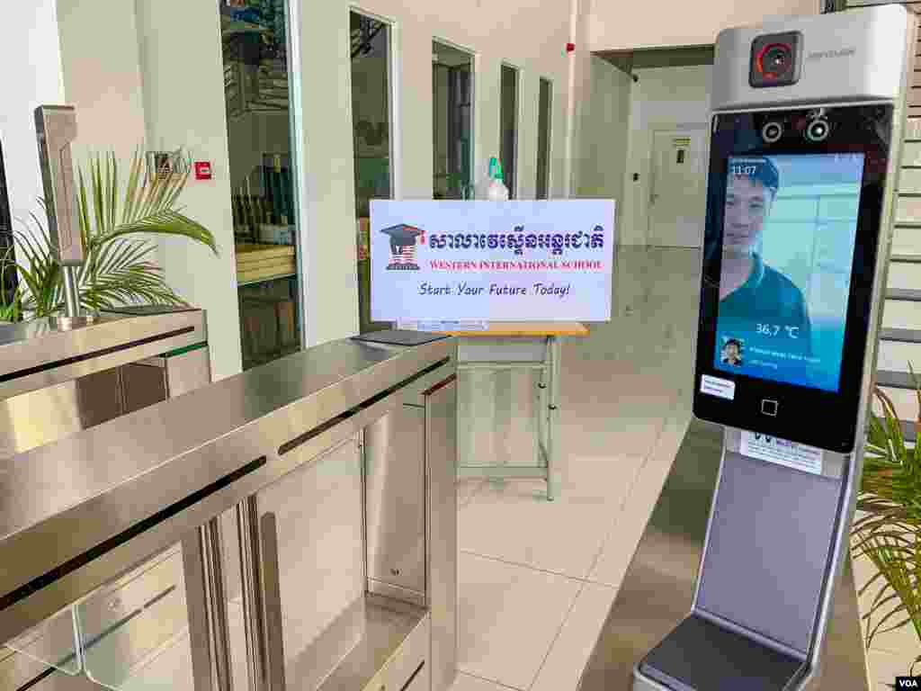 ម៉ាស៊ីន​វាស់​កំដៅទំនើប​ដែល​មាន​ទ្វារ ត្រូវបាន​ដាក់​ប្រើប្រាស់នៅ​សាលាវេស្ទើនអន្តរជាតិ។ ​បើសិន​ជា​អ្នក​ឆ្លង​កាត់ មាន​កំដៅ​លើស​ពី ៣៧,៥ អង្សារសេ ទ្វារ​មិន​បើក​ឲ្យ​ចូល​ទេ។ ម៉ាស៊ីននេះ​ប្រើ​សម្រាប់សិស្ស បុគ្គលិក​ទាំងអស់​នៅក្នុង​សាលា​វេស្ទើនអន្តរជាតិ មុនចូល​ទៅ​ក្នុង​សាលា ទីក្រុងភ្នំពេញ ថ្ងៃទី​៨ ខែកក្កដា ឆ្នាំ​២០២០។ (ធីតា វីន/វីអូអេ)