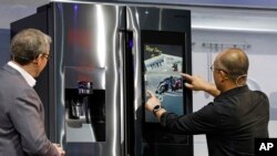 Yoon Lee, kanan, wakil presiden senior, Samsung Electronics America, menggunakan Family Board pada kulkas dalam konferensi pers Samsung pada CES International di Las Vegas, 7 Januari 2019 (foto: AP Photo/John Locher)