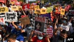 ក្រុម​បាតុករ​នាំ​គ្នា​លើក​​ផ្ទាំងបដា​ឡើង ក្នុង​​អំឡុងពេល​នៃ​ការ​តវ៉ា​មួយ​នៅ​ខាង​ក្រៅ​ធនាគារ​ជាតិ​មីយ៉ាន់ម៉ា​ប្រឆាំង​នឹង​រដ្ឋប្រហារ​យោធា​ ទីក្រុង​រ៉ង់ហ្គូន ប្រទេស​មីយ៉ាន់ម៉ា ថ្ងៃទី១៦ ខែកុម្ភៈ ឆ្នាំ២០២១។