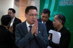 FILE - Thai Minister of Digital Economy and Society, Phutthipong Punnakan, center, greets during a news conference to announce the launching of government run anti-fake news center in Bangkok, Aug. 21. 2019.