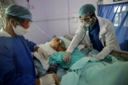 FILE - Medical workers attend to a COVID-19 patient in an intensive care unit at a hospital in Sana'a, Yemen, June 14, 2020.