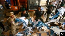 Cambodian rescuers work at the site of a factory collapse in Kai Ruong village, south of Phnom Penh, Cambodia, Thursday, May 16, 2013. The ceiling of the factory that makes Asics sneakers collapsed on workers early Thursday, killing two people and injuring seven, in the latest accident to spotlight lax safety conditions in the global garment industry. (AP Photo/Heng Sinith)