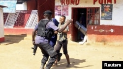 Photo d’archives : Des policiers face à un manifestant lors d'affrontements à Lubumbashi, en République démocratique du Congo, le 10 novembre 2015.