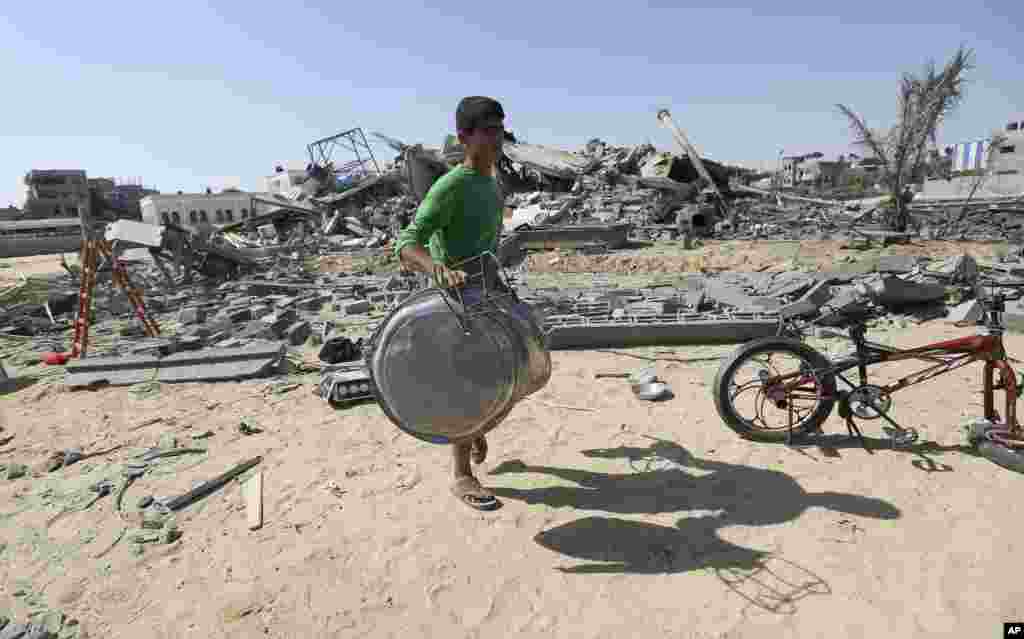 A Palestinian salvages what he can from a house after it was hit by an Israeli missile strike in Rafah, southern Gaza Strip, July 9, 2014.
