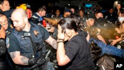 ตำรวจกรุงวอชิงตันฉีดสเปรย์พริกไทยสลายการชุมนุมที่ George Washington University ช่วงเช้าวันพุธที่ 8 พ.ค. 2024 (Sage Russell, GW Hatchet via AP)