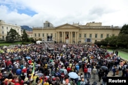 People listen as Colombia's President Gustavo Petro, flanked by First Lady Veronica Alcocer, delivers a statement about reforms that his government wants to carry out, during the May Day in Bogota, Colombia May 1, 2023. (REUTERS/Luisa Gonzalez)