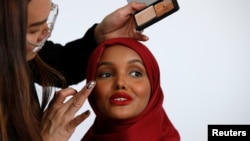 Fashion model and former refugee Halima Aden, has her makeup applied during a shoot at a studio in New York City, Aug. 28, 2017. 