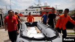 Tim SAR membawa kapal karet dengan KN Purworejo di belakang mereka, pada operasi pencarian pesawat AirAsia QZ8501 di Pangkalan Bun (6/1).