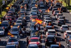People wave Spanish flags during a drive-in protest organized by Spain's far-right Vox party against the government's handling of the nation's coronavirus outbreak in Madrid, Oct. 12, 2020.