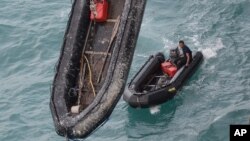 Penyelam Angkatan Laut Indonesia menunggu di sekoci mereka setelah menyelam untuk mengangkat ekor pesawat AirAsia QZ8501 di Laut Jawa, Kamis (8/1).