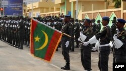 Un soldat maritanien porte le nouveau drapeau national lors d'une cérémonie, le 28 novembre 2017.