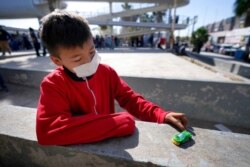 Dany Vargas Rodriguez, 10, of Honduras, plays with a toy car near the McAllen-Hidalgo International Bridge entry point into the U.S. after he and his family were caught trying to sneak into the U.S. and deported, March 18, 2021, in Reynosa, Mexico.