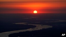 FILE - Ships travel along the Mississippi River in LaPlace, La., as the sun sets on Oct. 20, 2023. The nation’s rivers and streams remain stubbornly polluted with nutrients that contaminate water, according to a recently released Environmental Protection Agency assessment. 