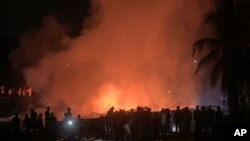 People work to put out a fire in a makeshift market near a Rohingya refugee camp in Kutupalong, Bangladesh, April 2, 2021.
