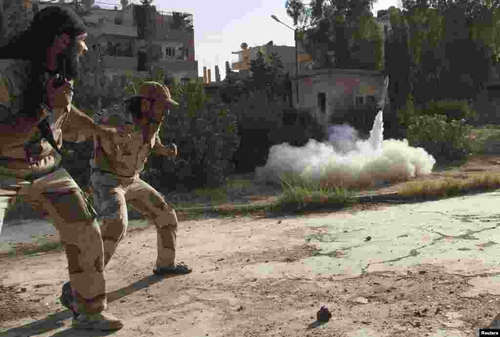 Members of the Free Syrian Army react as they fire a rocket in Deir al-Zor, June 16, 2013. 