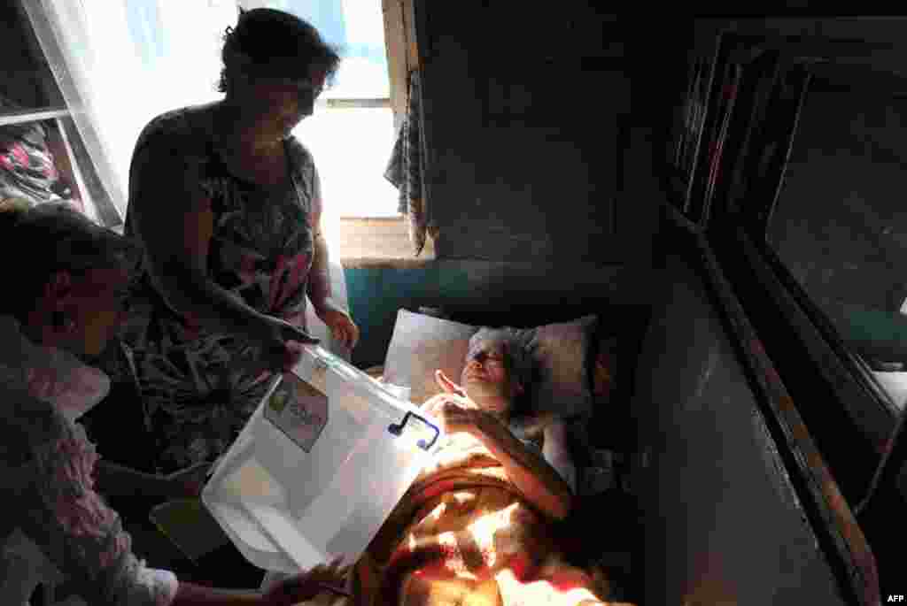 ხანდაზმული ქალბატონი სოფელ სართიჭალაში თავის ხმას აფიქსირებს, 1 ოქტომბერი, 2012