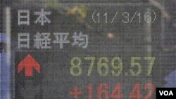 Seorang pria melongok papan indeks saham di jalanan kota Tokyo. Banyak perusahaan di negara ini menunda berbagai kampanye komersial selagi bencana masih menyita perhatian.