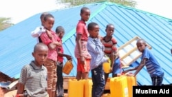Djeca sipaju vodu u kanistere u kampu za jemenske izbjeglice blizu glavnog grada Somalije Mogadiša. 