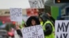 Seorang perempuan memegang poster yang berisi protes terhadap pemberlakuan mandat vaksin dalam aksi unjuk rasa di luar kantor perusahaan penerbangan Boeing di Everett, Washington, pada 15 Oktober 2021. (Foto: Reuters/Lindsey Wasson)
