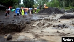 Para warga menyaksikan aliran banjir lahar dari abu vulkanis letusan Gunung Mayon di Guinobatan, Provinsi Albay, selatan Manila, Filipina, 27 Januari, 2018. 