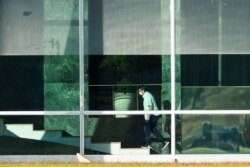 Presiden Brazil Jair Bolsonaro menaiki tangga di kediaman resminya, Istana Alvorada, di Brasilia, Brasil, Selasa, 14 Juli 2020.