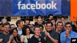 Pendiri Facebook, pemimpin perusahaan dan CEO, Mark Zuckerberg (tengah) saat menekan tombol pembukaan lantai bursa Nasdaq yang menandai IPO perusahaan tersebut, dari markas besar Facebook di Menlo Park, California, 18 Mei 2012 (Foto: dok).