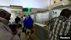 FILE - A man counts money inside the Faisal Islamic Bank in Khartoum, Sudan, Jan. 12, 2016. The pound plummeted to record lows on the black market in recent months, prompting the central bank to make two steep devaluations since the start of 2018. As of April 24, it officially trades at about 28 pounds to the dollar.