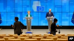 European Council President Charles Michel, right, and European Commission President Ursula von der Leyen, left, speak after a video-conference with G7 leaders at the European Council building in Brussels, Monday, March 16, 2020. 