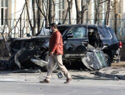 An Afghan security official inspects the site of a bomb blast in Kabul, Feb. 9, 2021.