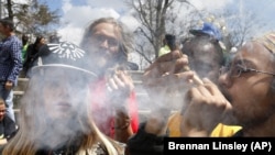 Young people listen to music and smoke marijuana during a yearly festival, in Civic Center Park in Denver, Colorado on April 18, 2015