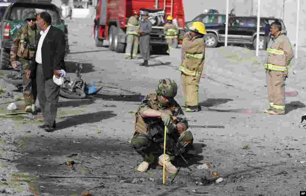 A French soldier investigates the scene of a suicide bombing that targeted a mini-bus carrying foreigners, Kabul, Afghanistan, September 18, 2012.