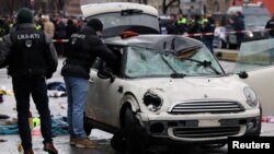 Police work at a car which drove into a crowd in Munich, Germany, Feb.13, 2025, injuring several people. 