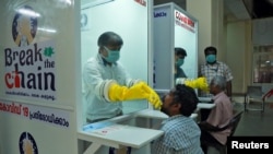Medical staff members of a government-run medical college collect swabs from people to test for coronavirus disease (COVID-19) at a newly installed Walk-In Sample Kiosk in Ernakulam in the southern state of Kerala, India, April 6, 2020.